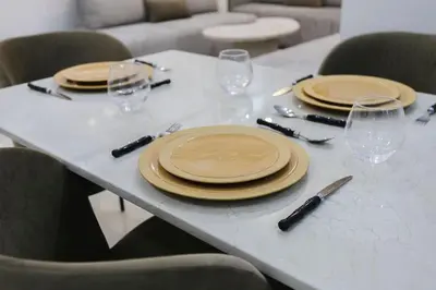 a table with plates and wine glasses on it at Golden Skyline – Marrakech in Marrakech