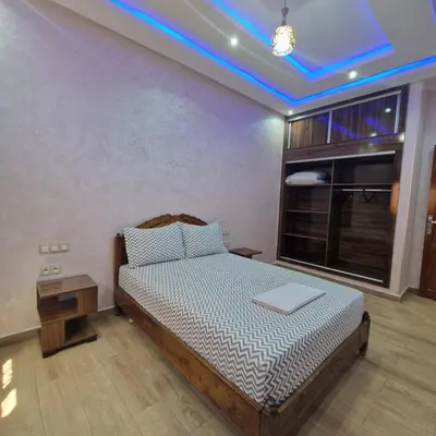 a bedroom with a bed with a blue ceiling at Bel appartement de 2 chambres L in Marrakech