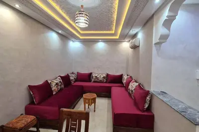 a living room with a red couch and a table at Bel appartement de 2 chambres L in Marrakech