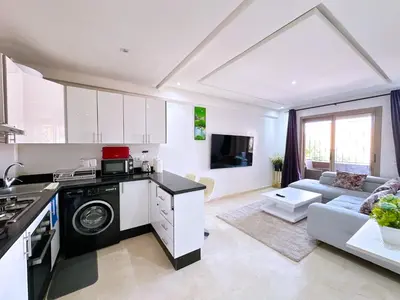 a kitchen and living room with a washer and dryer at Cosy Hyper centre Bd Hassan 2 in Marrakech