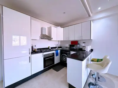 a kitchen with white cabinets and a black stove top oven at Cosy Hyper centre Bd Hassan 2 in Marrakech