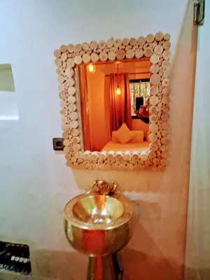 a bathroom with a sink in front of a mirror at Duplex Riad Abjaou in Marrakech