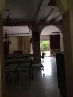 a dog standing in a living room with a table and chairs at Riad sofia in Marrakech
