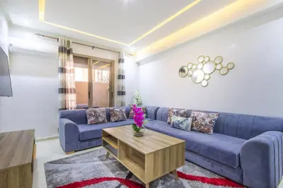 a living room with a blue couch and a table at NEW! Plein Gueliz, wifi, terrasse in Marrakech