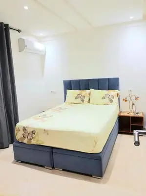 a bedroom with a bed with a blue headboard at New! Appartement en plein centre ville in Marrakech
