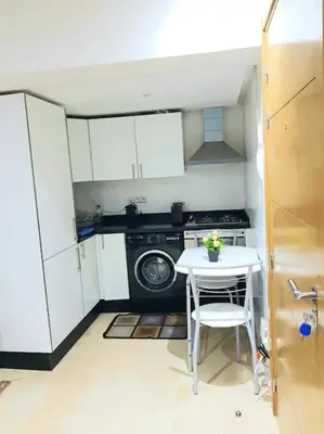 a small kitchen with a table and a washing machine at New! Appartement en plein centre ville in Marrakech