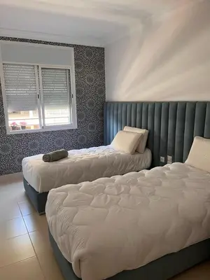 a bedroom with two beds and a window at Majorel Blue in Marrakech