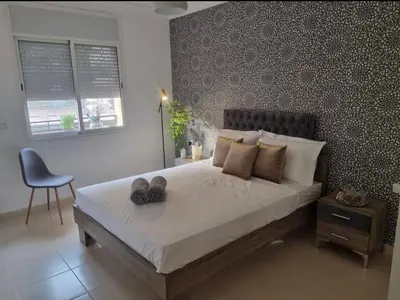 a bedroom with a large bed and a chair at Majorel Blue in Marrakech