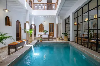 an indoor pool in a house with glass walls at Riad Bab Aljana in Marrakech