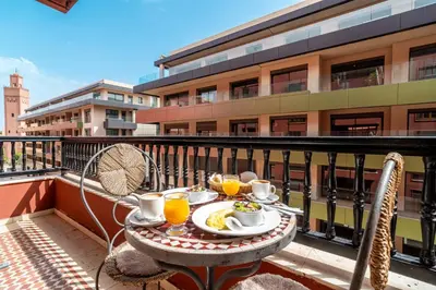 a table with a plate of food on a balcony at Appartement Haut standing Gueliz Plaza in Marrakech