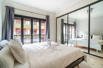 a bedroom with a large bed and a large window at Appartement Haut standing Gueliz Plaza in Marrakech