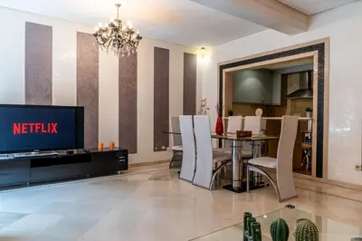 a living room with a dining table and a television at Appartement Haut standing Gueliz Plaza in Marrakech