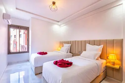 a bedroom with two beds with red roses on them at Charmante Wohnung im Herzen von Marrakesch Gueliz in Marrakech
