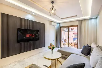 a living room with a couch and a tv at Charmante Wohnung im Herzen von Marrakesch Gueliz in Marrakech