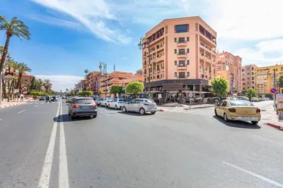 a busy city street with cars parked on the road at Charmante Wohnung im Herzen von Marrakesch Gueliz in Marrakech