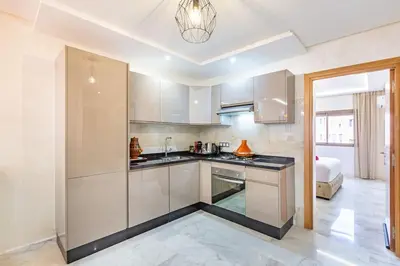 a kitchen with white cabinets and a bed in a room at Charmante Wohnung im Herzen von Marrakesch Gueliz in Marrakech