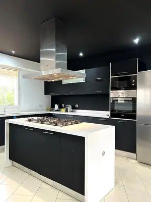 a kitchen with black cabinets and a white counter top at Séjour idéal a Marrakech - Villa spacieuse tout confort in Marrakech