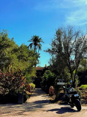 a motorcycle parked on a driveway in front of a house at Appartement Spacieux avec Piscine à la Palmeraie in Marrakech
