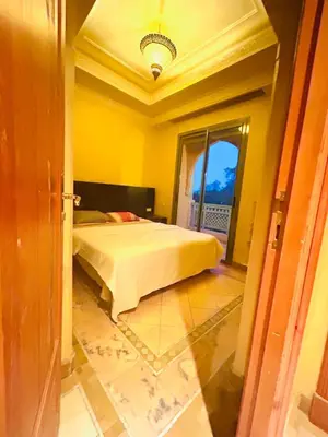 a bedroom with a bed in a yellow room at Appartement Spacieux avec Piscine à la Palmeraie in Marrakech