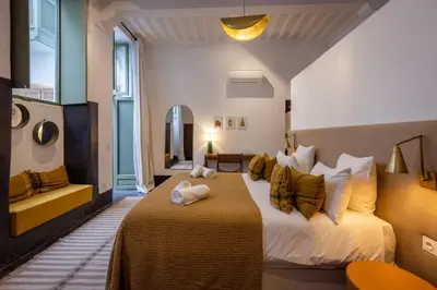 a hotel room with a bed and a mirror at Riad Dar Nakous in Marrakech