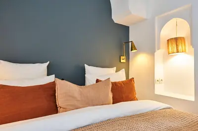 a bedroom with a bed with pillows and a blue wall at Riad Dar Nakous in Marrakech