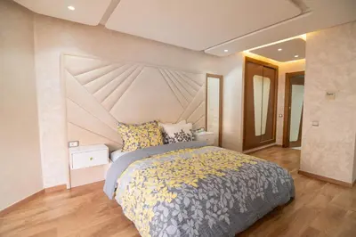 a bedroom with a large bed with a large headboard at Riad Gardens Two Bedroom Apartment in Marrakech