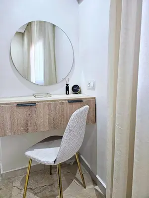 a mirror and a white chair in a bathroom at Coeur de Marrakech : Luxe, ciné & confort in Marrakech