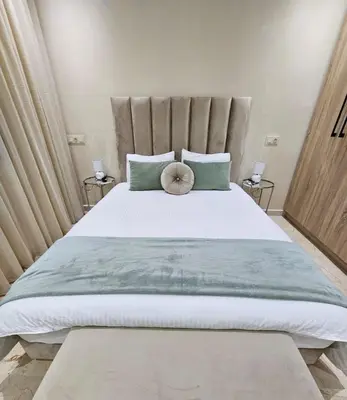 a bedroom with a large bed with green pillows at Coeur de Marrakech : Luxe, ciné & confort in Marrakech