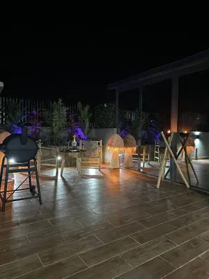 a patio at night with a table and chairs at Appartement Luxueux au Rooftop à Guéliz in Marrakech