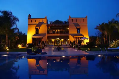 a large house with a swimming pool at night at Villa Malika Silvana in Marrakech