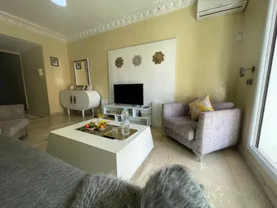 a living room with a couch and a tv at Joli appartement Gueliz centre ville in Marrakech