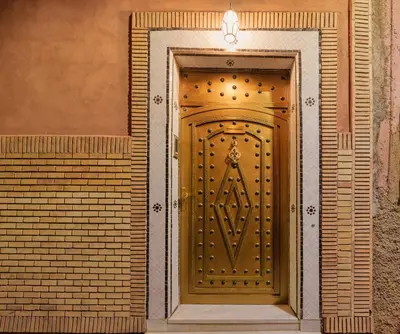 a wooden door in a brick wall with at Riad Dar Arwa in Marrakech