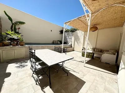 a patio with a table and chairs and a couch at Maison de ville avec piscine privée in Marrakech