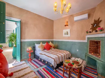 a bedroom with a bed and a fireplace at Riad dada Messouda spa in Marrakech
