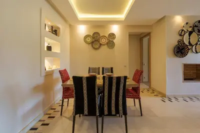 a dining room with a table with chairs and plates on the wall at Stylish Bliss - Dream Apartment in Marrakech