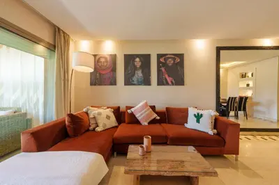 a living room with a brown couch and a table at Stylish Bliss - Dream Apartment in Marrakech