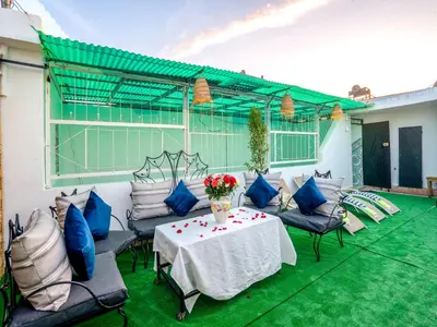 a patio with a table and some blue pillows at Agréable Maison de vacances in Marrakech