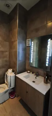 a bathroom with a sink and a toilet and a mirror at Appartement spacieux & lumineux à Gueliz in Marrakech