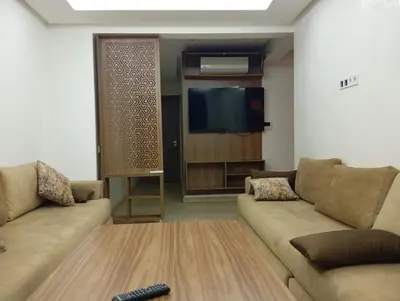 a living room with two couches and a flat screen tv at Appartement spacieux & lumineux à Gueliz in Marrakech