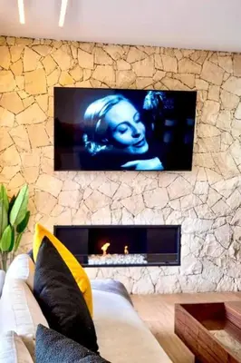 a living room with a couch and a stone fireplace at Appartement Marrakech Hivernage N37 RESIDENCE CAPRICE PALACE in Marrakech