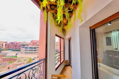 a room with a balcony with a view of a city at Appartement Marrakech Hivernage N37 RESIDENCE CAPRICE PALACE in Marrakech