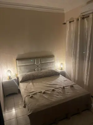 a bedroom with a bed with two lamps on it at Riad Aya in Marrakech