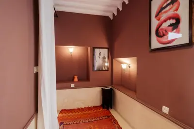 a hallway with a stairway with a red wall at Riad Zi in Marrakech