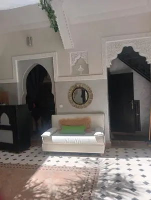 a living room with a white couch and a mirror at Le riad de l'étoile ocre - COTG in Marrakech
