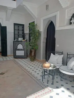 a living room with two chairs and a table at Le riad de l'étoile ocre - COTG in Marrakech