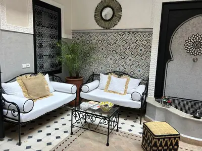 a living room with two white couches and a table at Le riad de l'étoile ocre - COTG in Marrakech