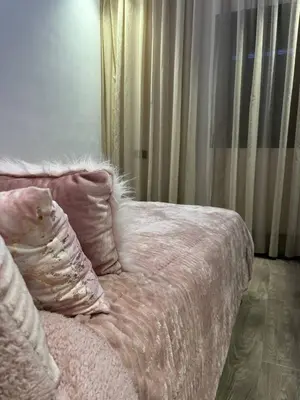 a bed with a pink comforter and a pillow at Luxueux Duplex 3 Chambres piscine,terrasse Hivernage Centre Marrakech in Marrakech