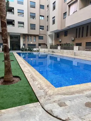 a large swimming pool in front of a building at Luxueux Duplex 3 Chambres piscine,terrasse Hivernage Centre Marrakech in Marrakech