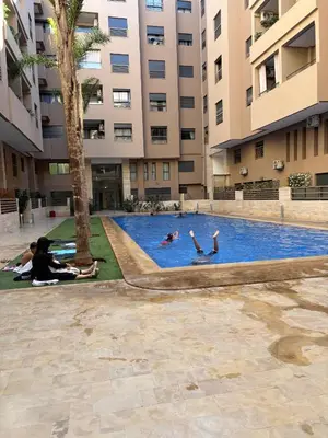 a group of people swimming in a pool in a building at Luxueux Duplex 3 Chambres piscine,terrasse Hivernage Centre Marrakech in Marrakech