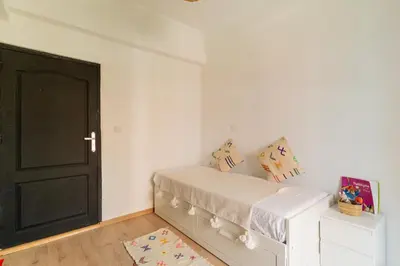 a bedroom with a bed and a black door at Appartement centre Marrakech gueliz - Cool & Cozy Apartment for a Family Stay in the Heart of the City in Marrakech